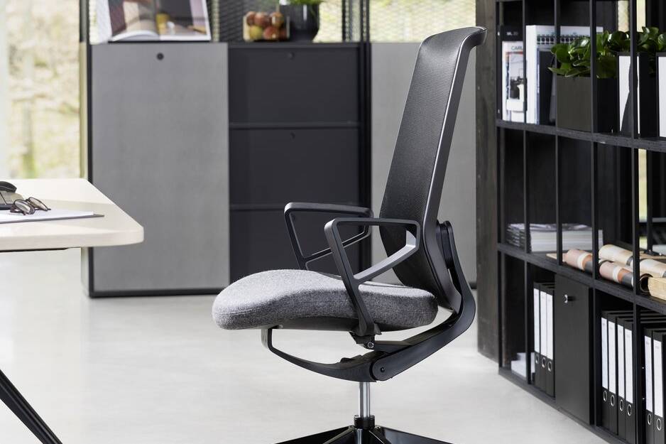 Home-Office mit Schreibtisch, Sideboard und Pendelleuchte vor blauer Wand