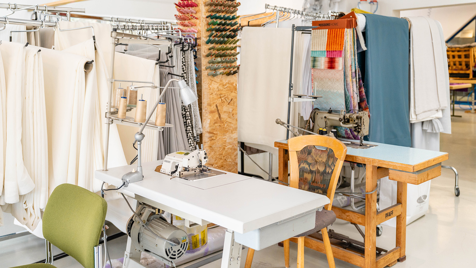 Werkstatt mit Nähtischen, Stoffen und Arbeitsmaterial