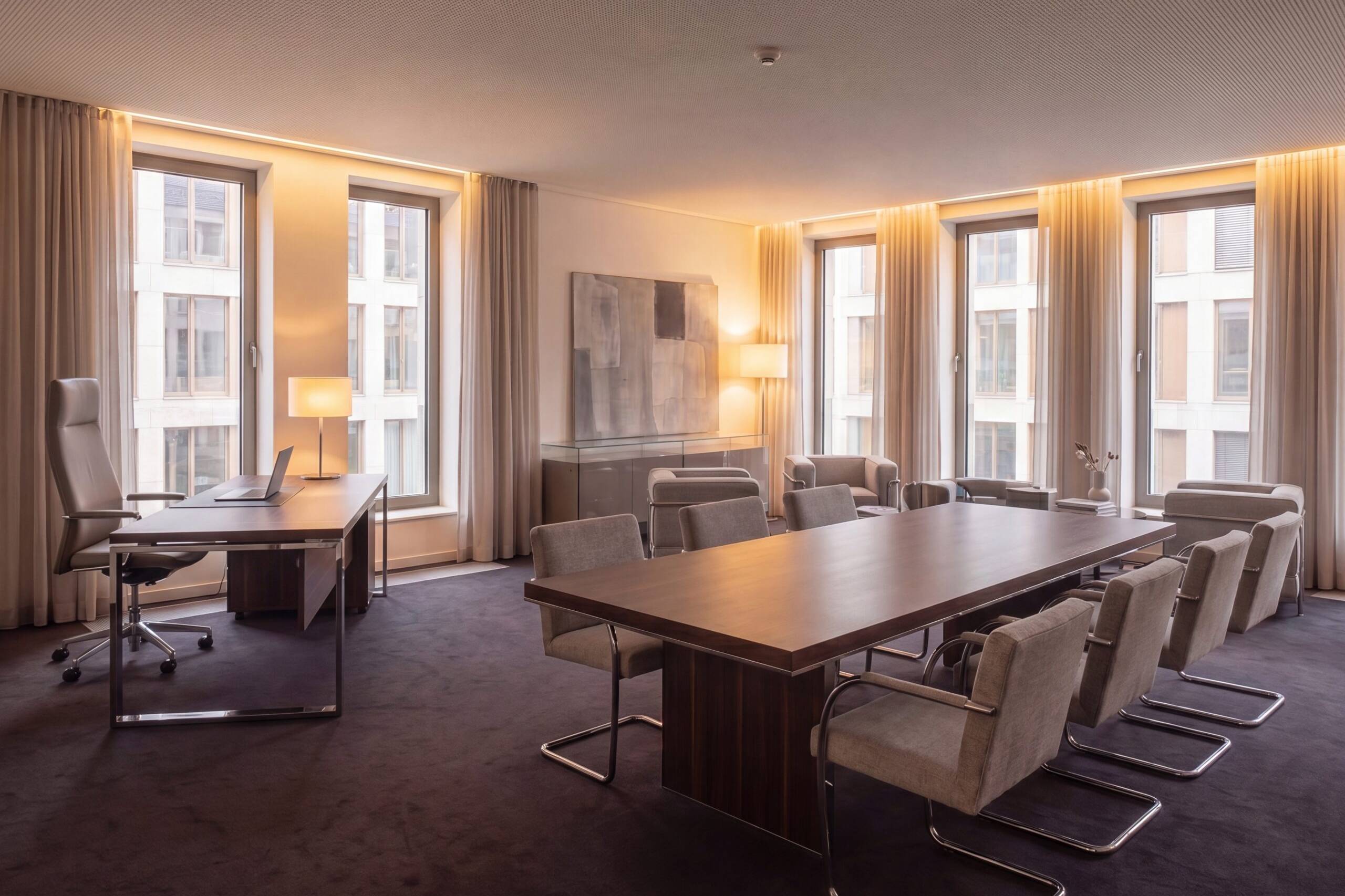 Büro mit Konferenztisch, Arbeitsplatz und Fensterfront