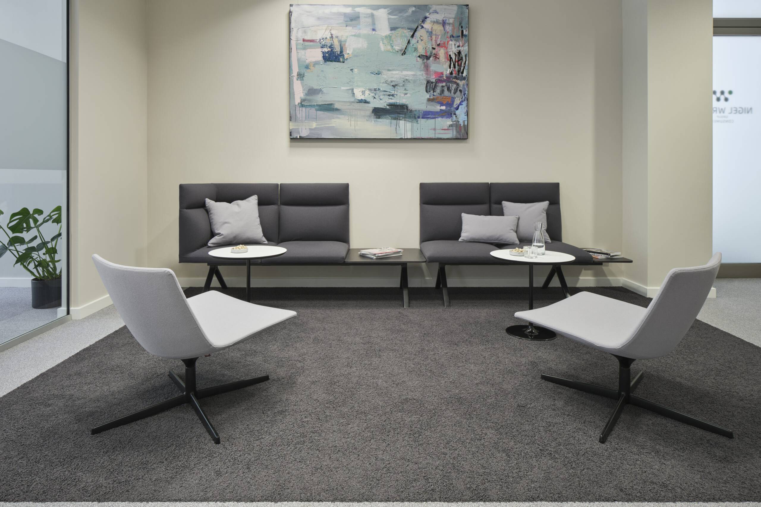 Wartebereich mit Loungesesseln, Sitzbank und Kunstwerk