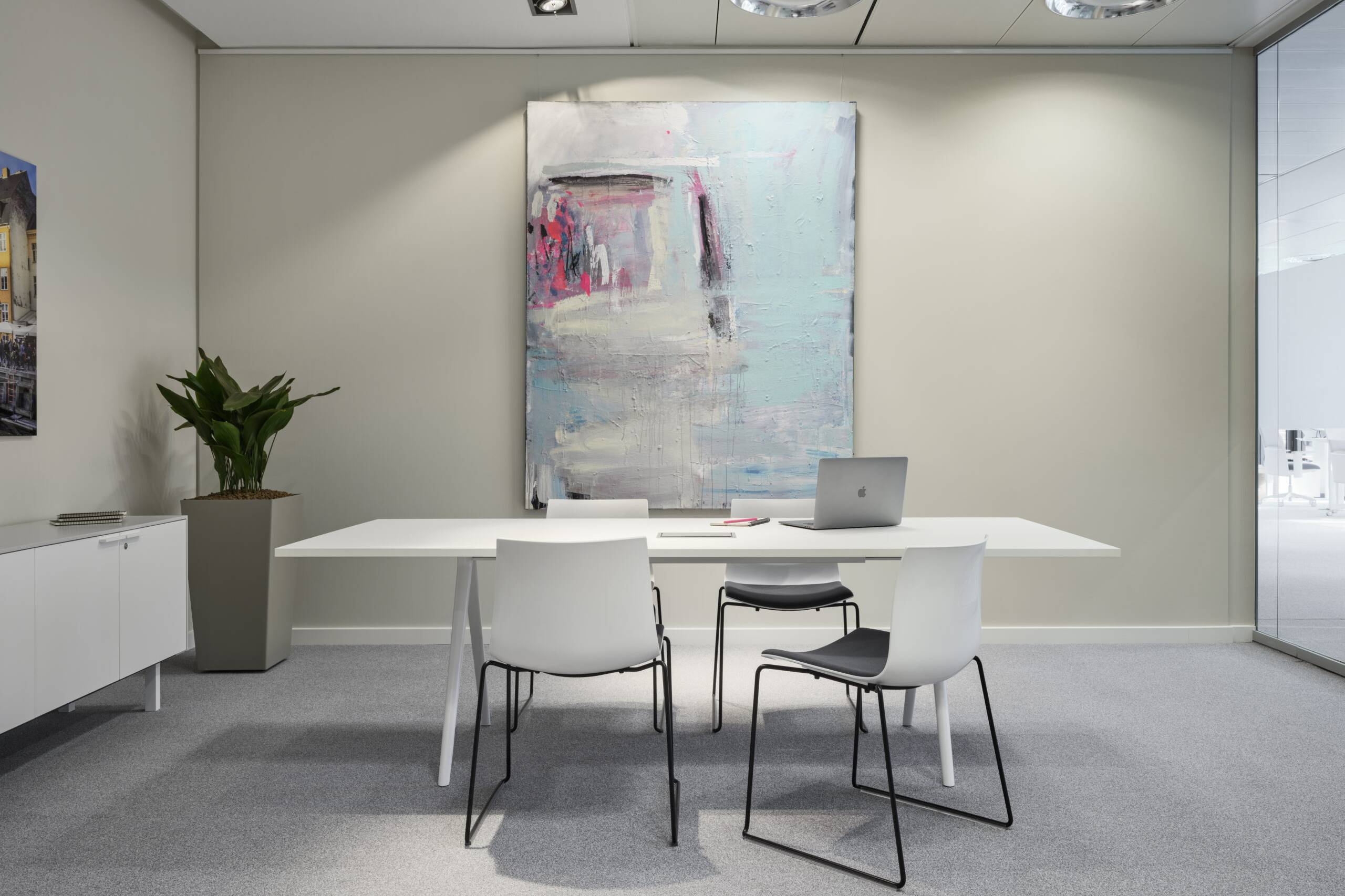 Besprechungsraum mit langem Tisch und großformatigem Kunstwerk