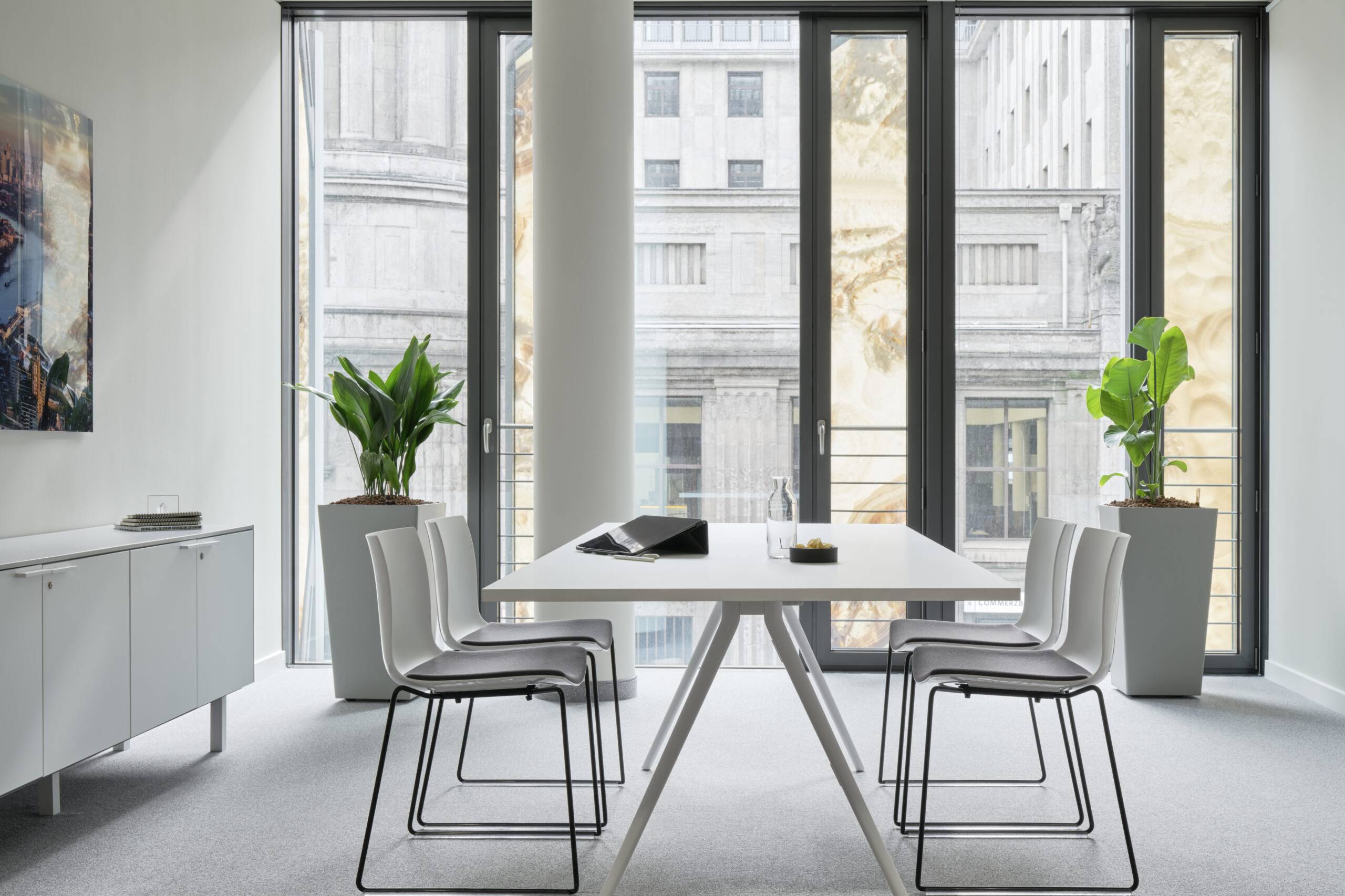 Besprechungstisch mit Freischwingern vor bodentiefer Fensterfront